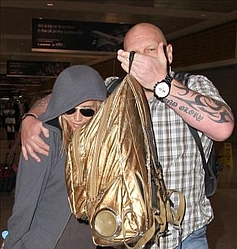 Kesha covers up at Sydney airport