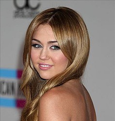 Miley Cyrus tucks into cupcakes backstage at the KCAs